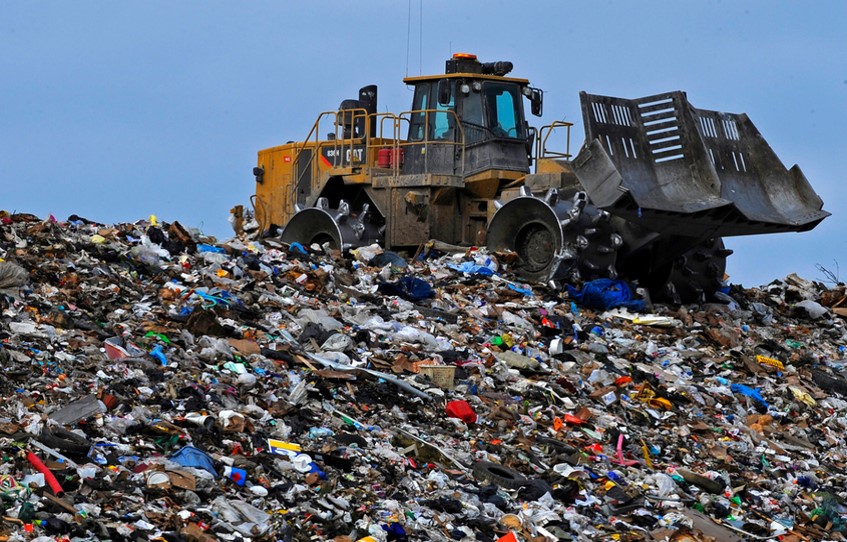 mountain of garbage with a bulldozer on it